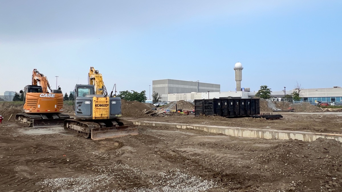 Two excavators clearing a demolished site down to grade
