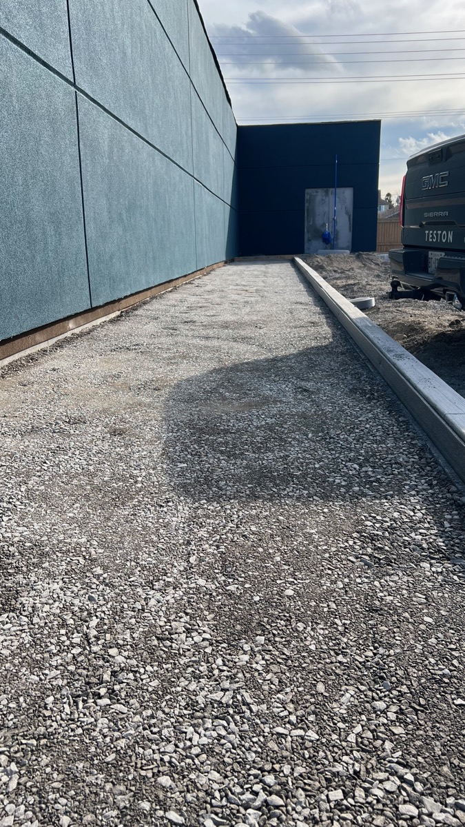 Teston crew preparing a gravel base with the company truck on site