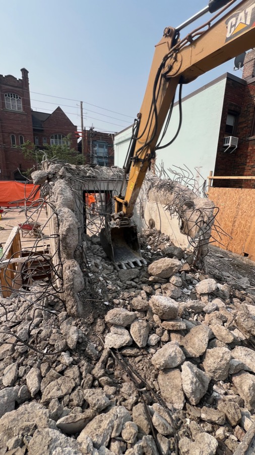 Excavator breaking out a concrete structure during a demolition