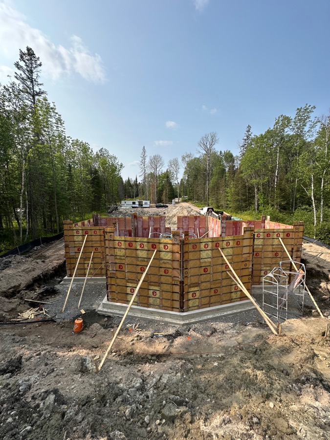 Formed concrete foundation walls on a wooded build site